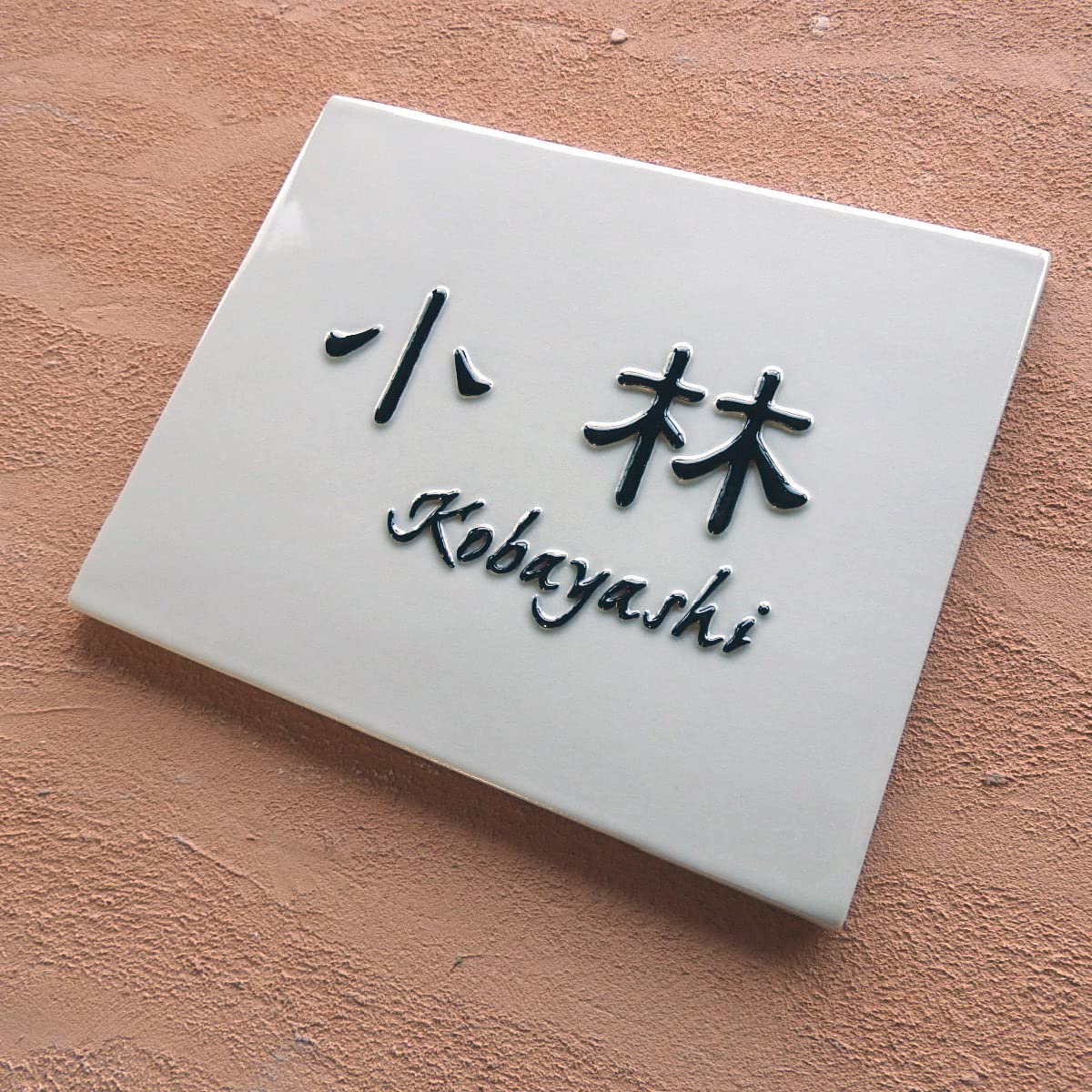 Amazon | 風水的にも良い白地に黒の浮き出し文字のシンプルな陶器表札